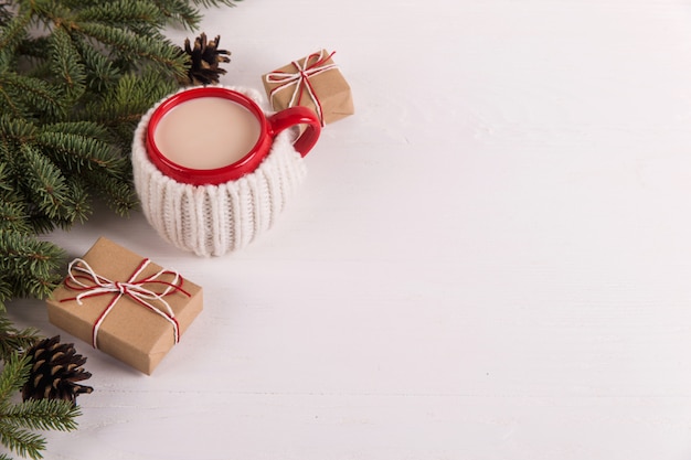 Gałęzie choinkowe, prezenty i gorący napój w kubku, Boże Narodzenie, kartkę z życzeniami. copyspace.