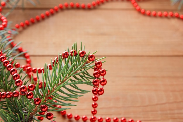 Zdjęcie gałęzie jęczmienia i czerwony naszyjnik na drewnianych deskach ozdoby bożonarodzeniowe na drewnianym tle