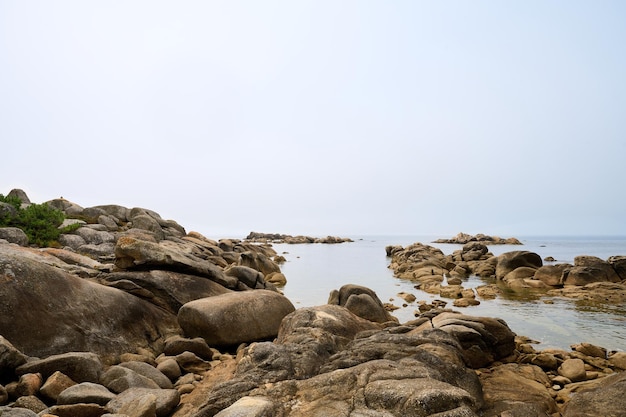 Galicyjska plaża ze skałami i niebieskim niebem. Tło natura.