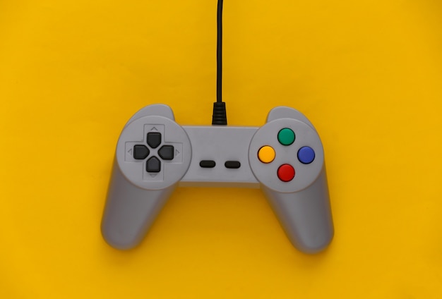 Gamepad do gier wideo. Koncepcja gier retro joystick na żółto.