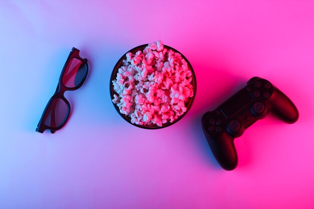Gamepady, pilot do telewizora, okulary 3D i miska popcornu