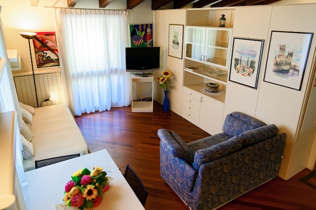 Zdjęcie gargnano, włochy-13 lipca 2019: nowoczesne, wygodne wnętrze pokoju z sofą. luksusowe wnętrze sypialni w hotelu lub mieszkaniu w domu. koncepcja i projekt architektoniczny. podwójne łóżko w domu.