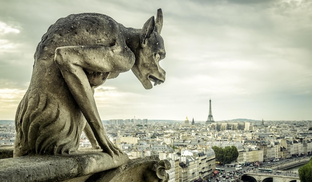 Gargulec na katedrze Notre Dame de Paris patrzy na wieżę Eiffla Paryż Francja