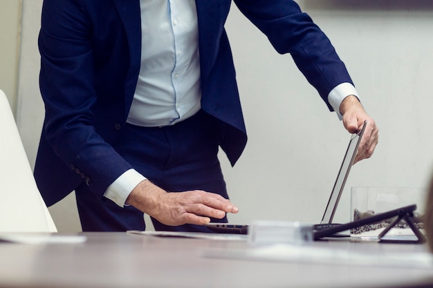 Zdjęcie garnitur ubrany mężczyzna za pomocą laptopa w biurze