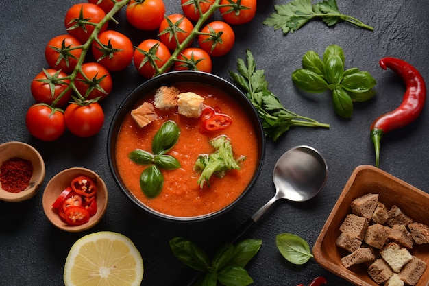 Gazpacho andaluzyjskie. Zimna zupa gazpacho z czerwonych pomidorów w szklance, z ogórkiem, cebulą, bazylią, papryczkami chili i grzankami.