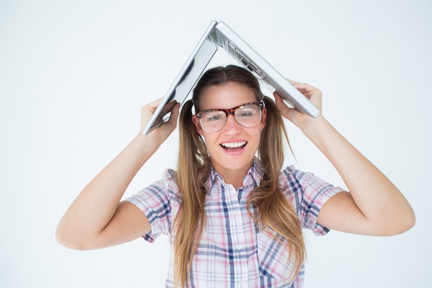 Geeky hipster trzymając jej laptop nad głową