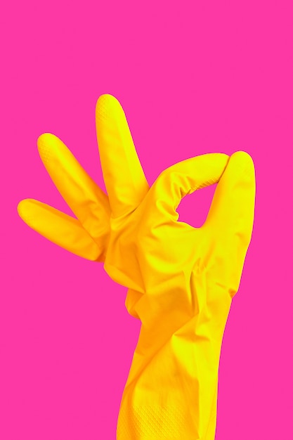 Gest dłoni OK w żółtej gumowej rękawicy
