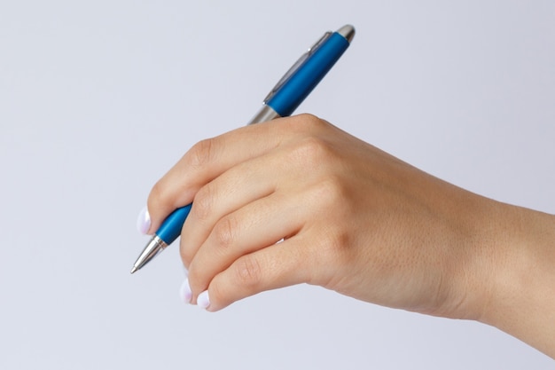 Gest i znak, ręka trzyma metalowy niebieski długopis na białym tle