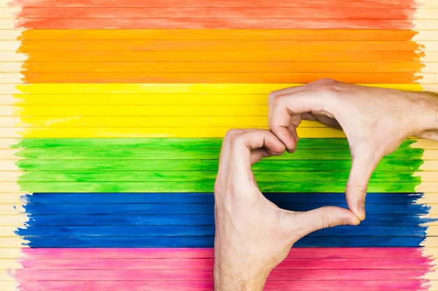 Gest parady gejów i koncepcja homoseksualna pokazująca symbole na tle paska tęczowej flagi