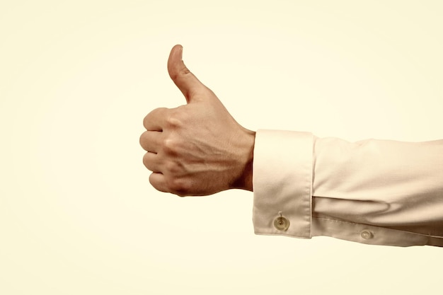 Gest zatwierdzenia kciuka w górę z męską ręką odizolowaną na białym aprobacie