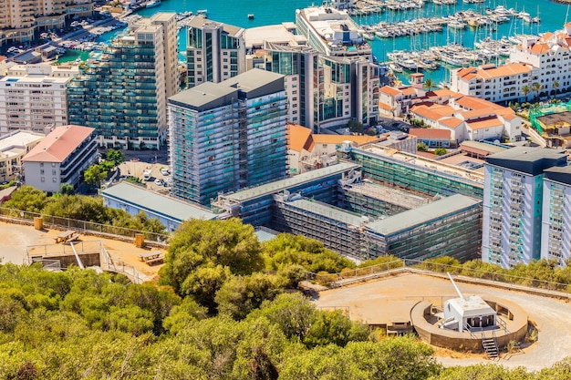 Gibraltar widok na panoramę centrum miasta ze Skały Gibraltarskiej ze starymi działami artyleryjskimi na pierwszym planie