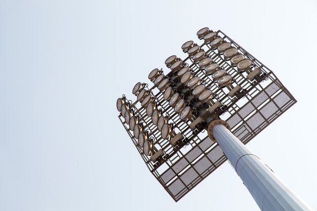 Gigantyczne reflektory są na stadionie do wysokiego słupa na tle nieba