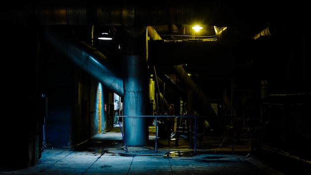 Gigantyczne rury i urządzenia wewnątrz nowoczesnej sceny nocnej elektrowni przemysłowej Przemysłowa scena nocna