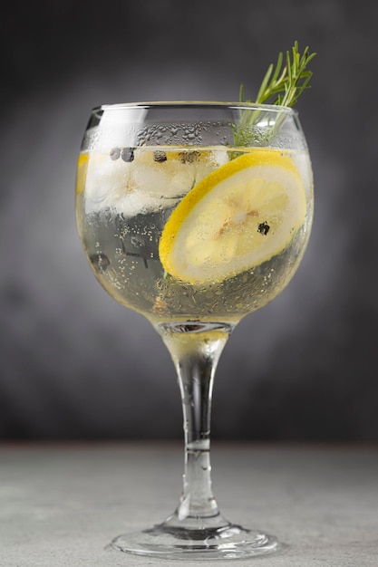 Zdjęcie gin tonic przyozdobiony cytryną i rozmarynem