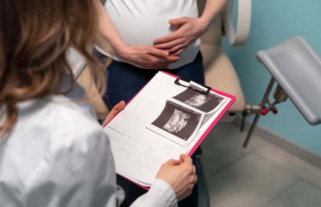 Zdjęcie ginekolog oceniający ciążę z pacjentką