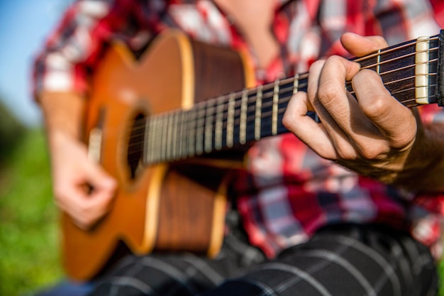 Gitary akustyczne Mężczyzna muzyk gra na gitarze instrument muzyczny Ręce mężczyzny gra na gitarze akustycznej z bliska Gitary akustyczne gra Koncepcja muzyki