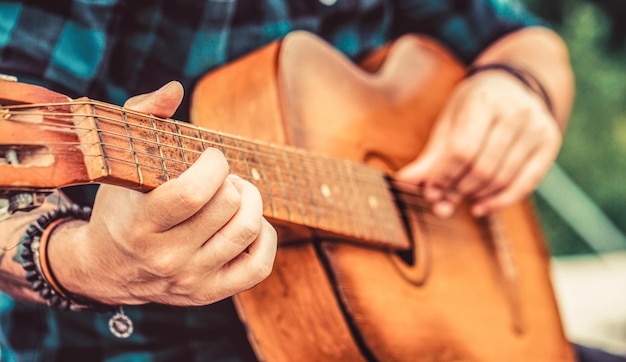 Gitary akustyczne Muzyka na żywo Festiwal muzyczny Mężczyzna muzyk grający na gitarze instrument muzyczny Ręce mężczyzny grający na gitarze akustycznej z bliska