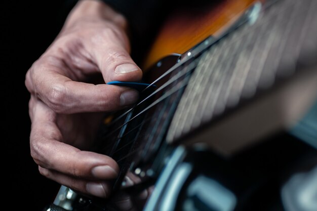 Gitarzysta ręce i struny gitary z bliska