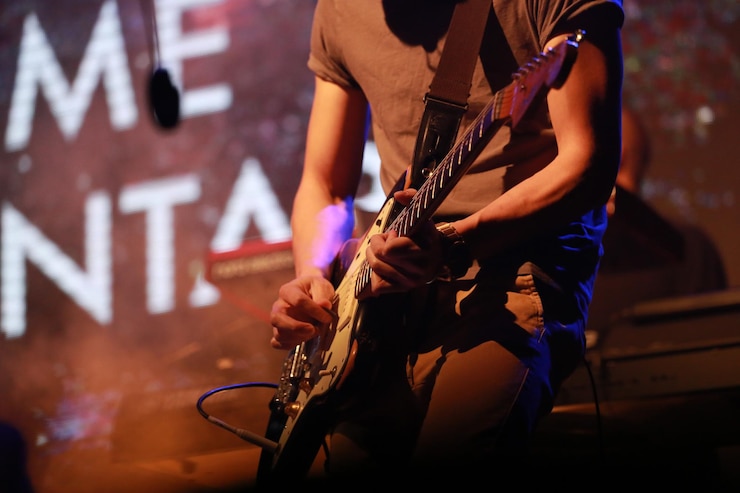 Zdjęcie gitarzysta w środkowej sekcji występujący na scenie na koncercie muzycznym