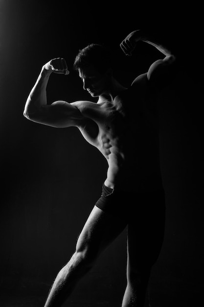 Gladiator lub atlant Sport i trening Adam z nagą klatką piersiową Mężczyzna z muskularnym ciałem Atletyczna pozycja kulturysty w spodniach