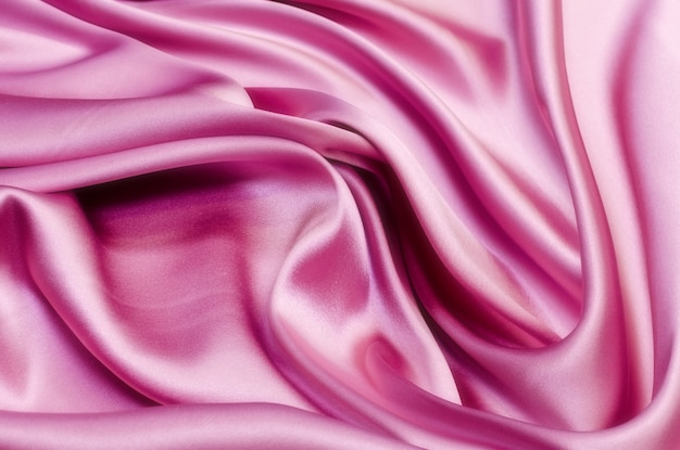 Gładka elegancka różowa tekstura jedwabiu lub satyny może służyć jako tło weselne. Luksusowy projekt tła