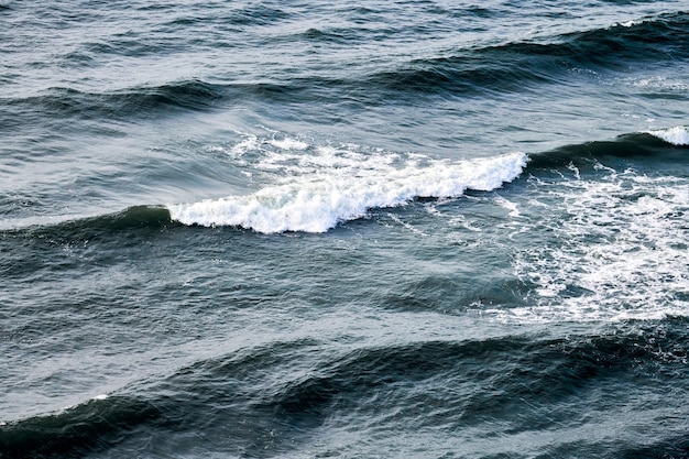 Zdjęcie głęboko niebieskie wody morza rozpryskujące się z piankowymi falami z powietrza widok fal oceanicznych ciemno niebieskiego falistego morza