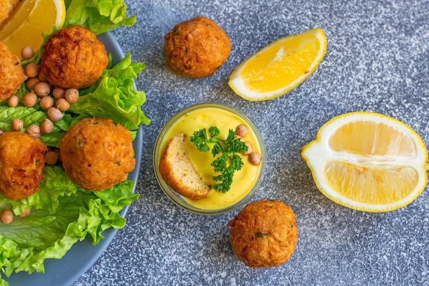 Zdjęcie głęboko smażony domowy falafel wegetariański wykonany z mielonej ciecierzycy i brokułów z sosem musztardowo-cytrynowym