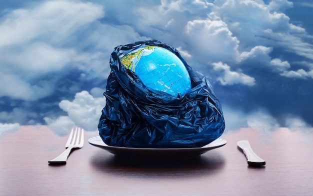 Zdjęcie globus na talerzu z widelcem i nożem w niebie