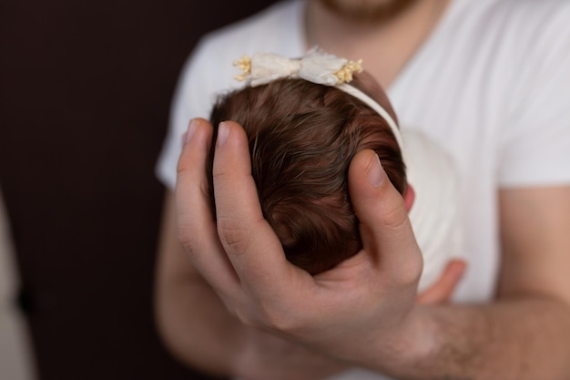 głowa noworodka w dłoni ojca. mała główka noworodka. dziecko w ramionach par