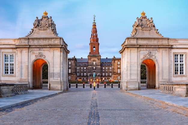 Główne wejście do Christiansborg z dwoma rokokowymi pawilonami po obu stronach Marmurowego Mostu podczas porannej niebieskiej godziny, Kopenhaga, stolica Danii