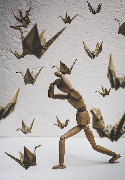 Zdjęcie głupiec ucieka od papierowych ptaków.