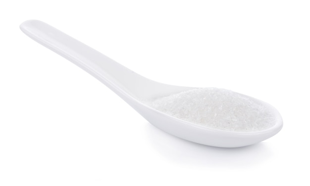 Glutaminian sodu w łyżce na białym tle