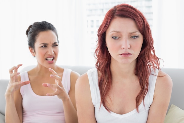 Zdjęcie gniewni żeńscy przyjaciele ma argument w pokoju dziennym