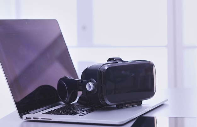Gogle wirtualnej rzeczywistości na biurku z laptopową technologią biznesową 3D