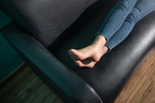 Gołe nogi kobiety leżącej na kanapie.