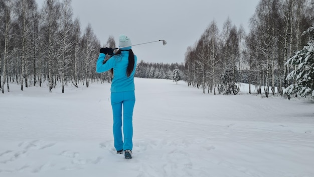 Golf w śniegu z piłkowym golfistą z klubem