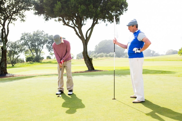Golfer kołyszący swój klub z przyjacielem