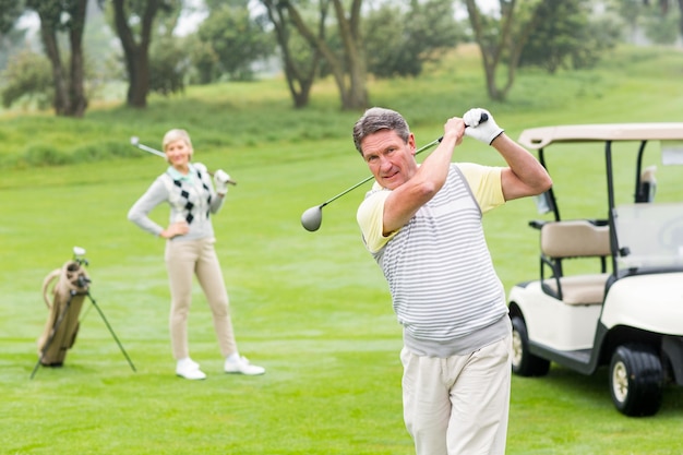 Golfer ma zamiar zagrać z partnerem za nim