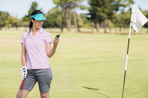 Golfista kobieta używa telefon