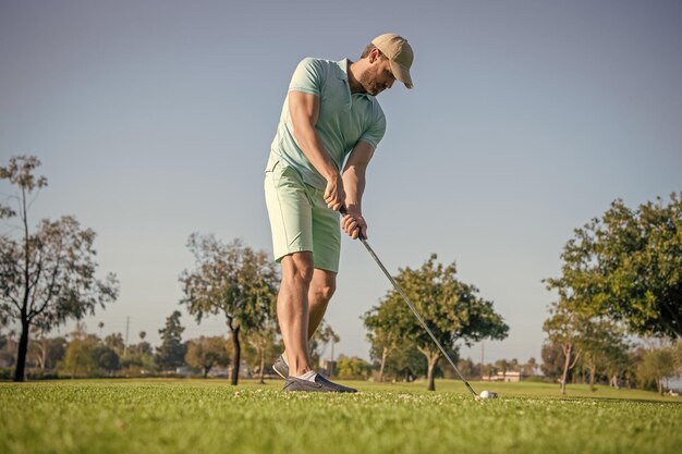 Golfista w czapce z klubem golfowym ludzie styl życia nieogolony mężczyzna grający w grę na zielonej trawie