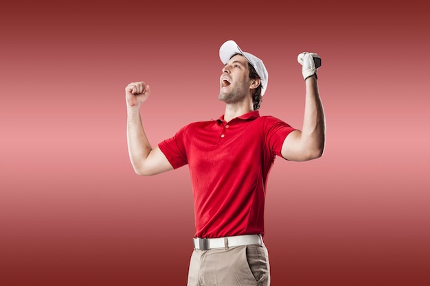 Golfista w czerwonej koszuli świętuje, na czerwonym tle.