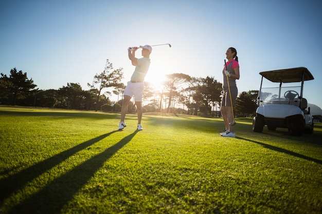 Golfowego gracza pary pozycja na trawiastym polu