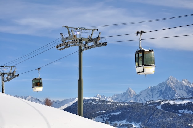 Gondola w alpejskim kurorcie górskim nad szczytem zaśnieżonej góry