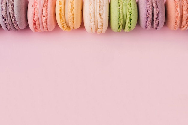 Zdjęcie góra granicy wykonane z kolorowych macaroons na różowym tle