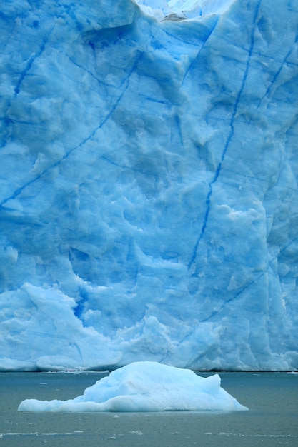 Góra lodowa unosi się nad jeziorem Argentino z lodowcem Perito Moreno, El Calafate, Patagonia, Argentyna