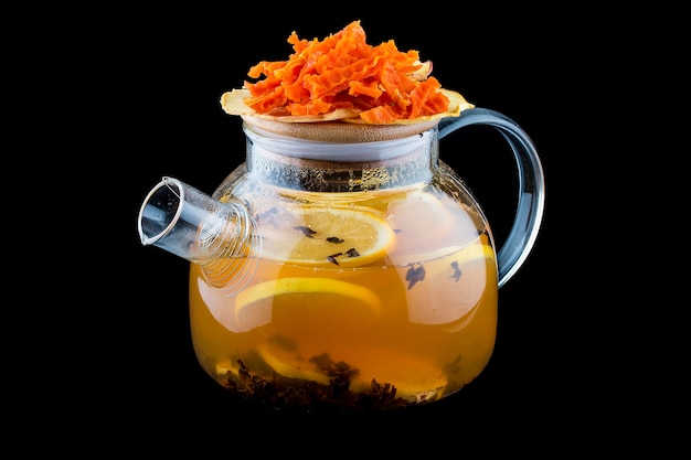 Gorąca herbata z rokitnikiem w szklanym czajniczku na ciemnym tle Z chipsami z dyni