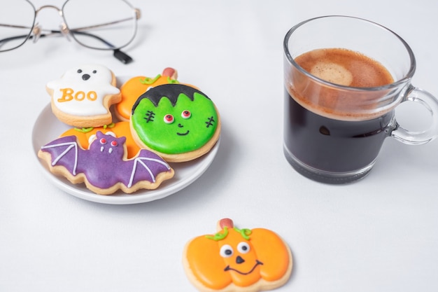 Gorąca kawa espresso lub filiżanka czekolady z zabawnymi ciasteczkami Halloween. Happy Halloween Day, Trick or Threat, Hello October, jesień jesień, tradycyjna, imprezowa i świąteczna koncepcja