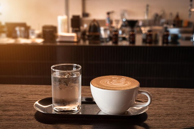 Gorąca kawa latte z pianką mleczną latte art w kształcie łabędzia w kubku na drewnianym biurku na widoku z góry jako śniadanie w kawiarni w kawiarni podczas koncepcji pracy biznesowej