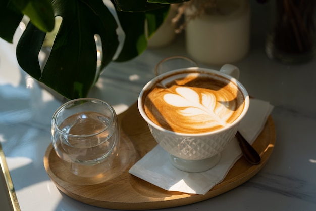 Gorąca kawa latte z pianką mleczną latte art w kubku filiżanki na drewnianym biurku na widoku z góry. Jako śniadanie W kawiarni w kawiarni, podczas koncepcji pracy biznesowej