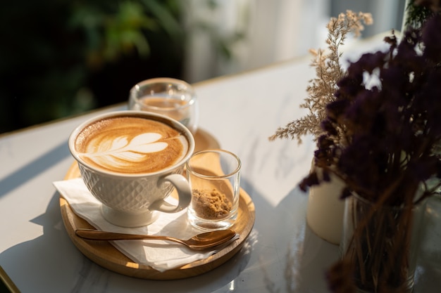 Gorąca kawa latte z pianką mleczną latte art w kubku filiżanki na drewnianym biurku na widoku z góry. Jako śniadanie W kawiarni w kawiarni, podczas koncepcji pracy biznesowej